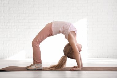 Beden dersinde minderde jimnastik yapan küçük kız.