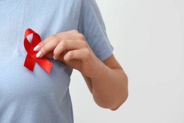 Beyaz arka planda kırmızı kurdeleli bir kadın. AIDS Günü konsepti