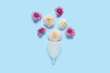 Mavi arka planda çiçekli regl bardağı