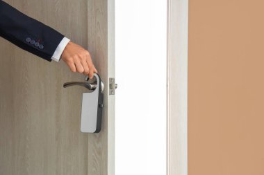 Otel odasında kapı askısı olan bir iş adamı, yakın plan.