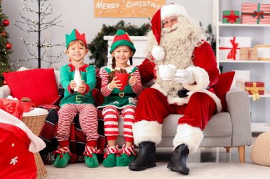 Noel Baba 'nın yanında küçük elfler ve Noel arifesinde evde içkiler