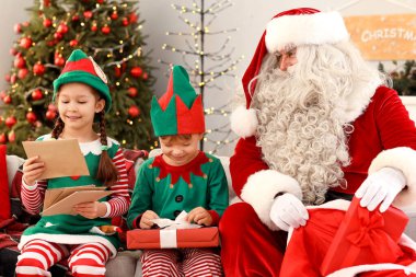 Noel hediyeli küçük elfler ve evde Noel Baba 'ya yardım eden mektuplar.