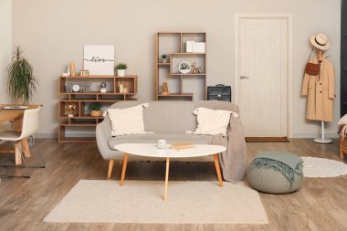 Oturma odasının içinde kanepe, raf üniteleri ve kapı var.