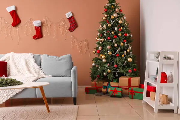 Interior of living room with sofa, Christmas socks and fir tree