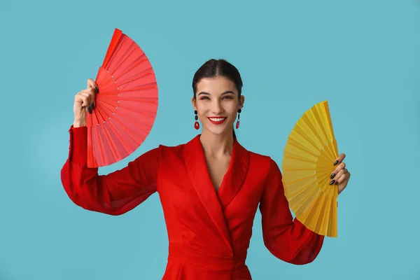 Beautiful young happy woman with fans on blue background. Chinese New Year celebration