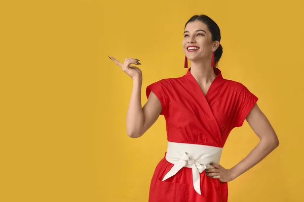 Piękna Młoda Szczęśliwa Kobieta Wskazująca Coś Żółtym Tle Chiński Nowy — Zdjęcie stockowe