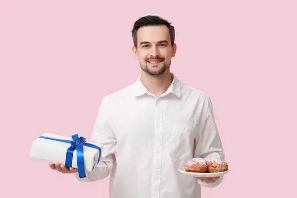 Schöner Erwachsener Mann Mit Sufganiyots Und Geschenkbox Auf Rosa Hintergrund — Stockfoto