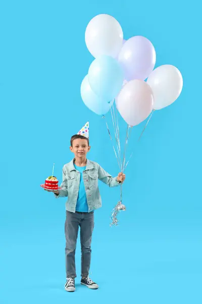 Cute little boy with Birthday cake and balloons on blue background