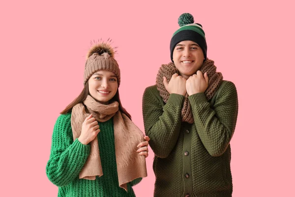 穿着粉色背景冬季服装的年轻夫妇 — 图库照片