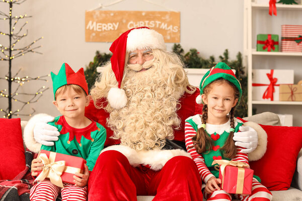 Little elves with Christmas gifts and Santa Claus at home