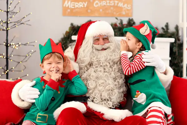 Little elves with Santa Claus at home on Christmas eve