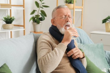 Hasta, olgun bir adam evde su içiyor.