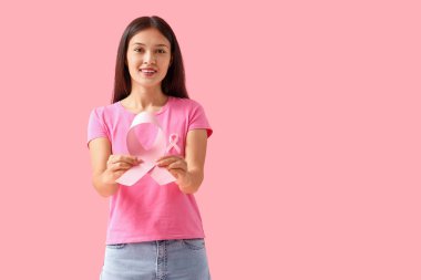 Pembe kurdeleli genç bir Asyalı kadın. Göğüs kanseri farkındalığı konsepti