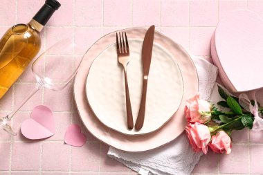 Sevgililer Günü için pembe fayanslı güller ve şarap şişesiyle güzel bir masa.