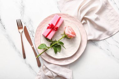 Beyaz grunge arka planda Sevgililer Günü için gül ve hediyeli güzel bir masa.