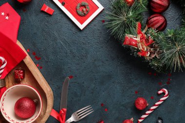 Koyu yeşil grunge arka planda süslemeleri olan Noel yemeği için güzel masa düzeninden yapılmış çerçeve