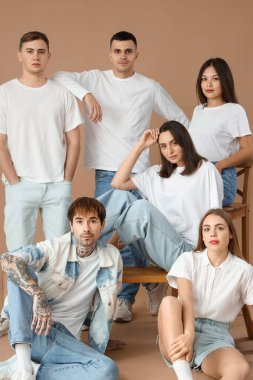 Kahverengi arka planda bir grup şık genç.