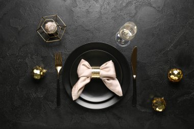 Noel topları ve siyah arka planda mumlarla güzel bir masa.