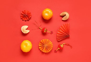 Mandalinalı şans kurabiyeleri ve kırmızı arka planda Çince semboller. Yeni yıl kutlaması