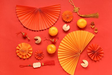 Mandalinalı şans kurabiyeleri ve kırmızı arka planda Çince semboller. Yeni yıl kutlaması