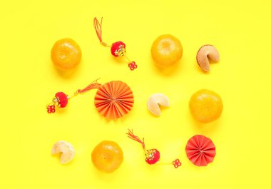 Mandalinalı şans kurabiyeleri ve sarı arka planda Çince semboller. Yeni yıl kutlaması