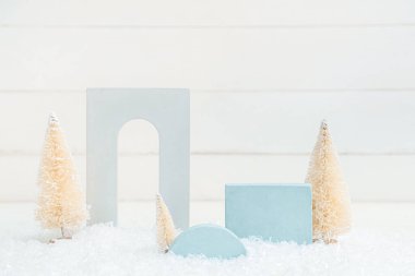 Süslü Noel ağaçları kar ve beyaz ahşap arka planda sıva kürsüleri