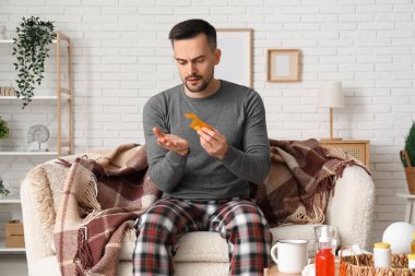 Hasta genç adam evde hap alıyor.