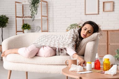 Hasta genç kadın evdeki kanepede yatıyor.