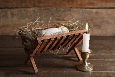 Bebek sahibi ahır ve ahşap arka planda yanan mum. Noel hikayesi kavramı