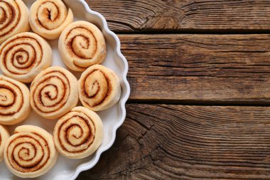 Ahşap arka planda pişmemiş tarçınlı fırın yemeği.