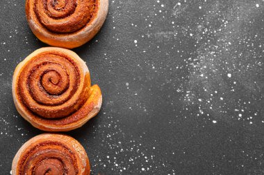 Siyah arkaplanda lezzetli tarçınlı rulo