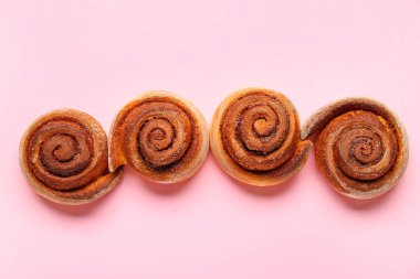 Pembe arka planda lezzetli tarçınlı rulo.