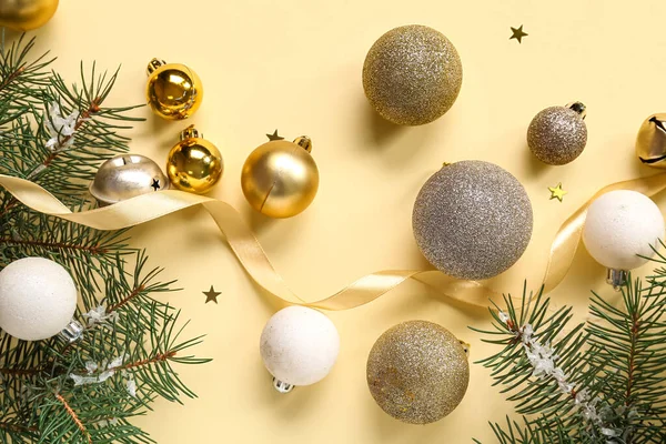 Sarı arka planda Noel baloları ve köknar dalları