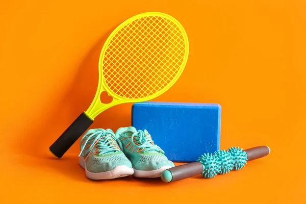 Turuncu arka planda farklı spor ekipmanları