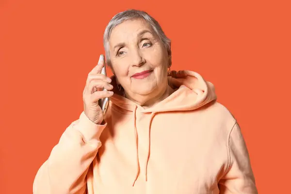 Senior Mulher Falando Por Telefone Celular Fundo Laranja Close — Fotografia de Stock