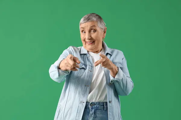 Senior Mulher Apontando Para Espectador Fundo Verde — Fotografia de Stock