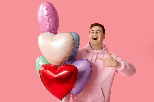 Junger Mann Mit Herzförmigen Luftballons Die Auf Etwas Auf Rosa — Stockfoto