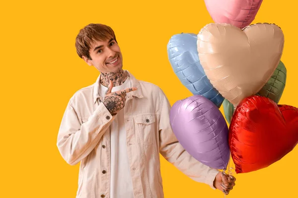 Jovem Feliz Com Balões Forma Coração Fundo Amarelo — Fotografia de Stock