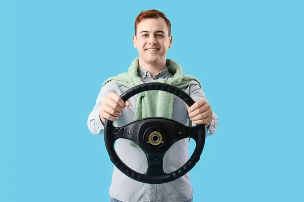 Lächelnder Junger Mann Mit Lenkrad Auf Blauem Hintergrund — Stockfoto