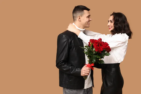 Amante Pareja Joven Con Ramo Hermosas Rosas Sobre Fondo Marrón —  Fotos de Stock
