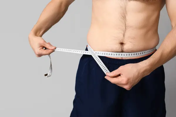 Handsome Sporty Young Man Measuring His Waist Grey Background Closeup Stock Image