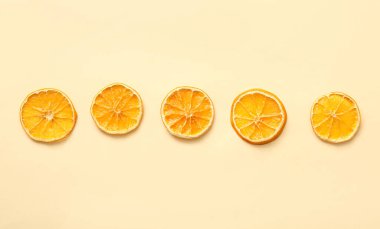 Sarı arka planda kurutulmuş portakal dilimleri