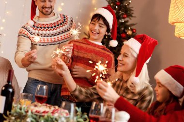 Havai fişekli büyük bir aile akşam evde Noel yemeği yiyor.