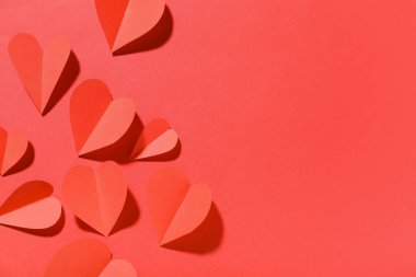 Kırmızı arka planda kağıt kalpler. Sevgililer Günü kutlaması