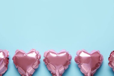 Mavi arka planda pembe kalp şekilli hava balonları