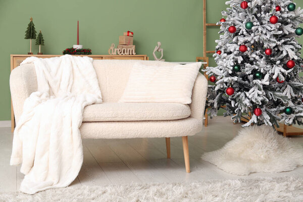 Interior of living room with beautiful decorated Christmas tree, sofa and dresser