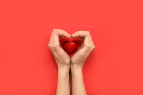 Kırmızı Arka Planda Kadın Elleri Seramik Kalp Sevgililer Günü Kutlaması — Stok fotoğraf