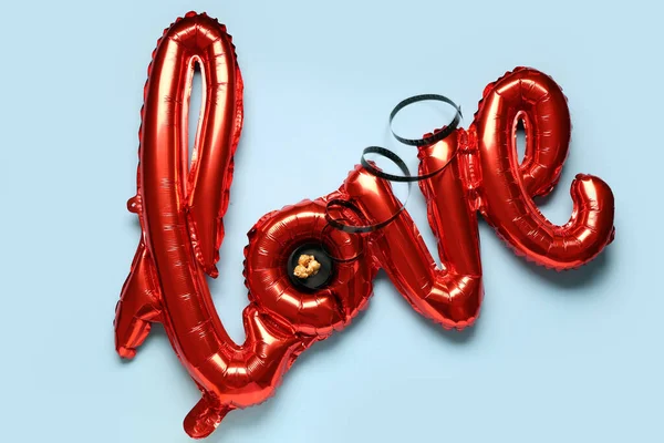 stock image Air balloons in shape of word LOVE with film reel and popcorn on blue background. Valentine's Day celebration