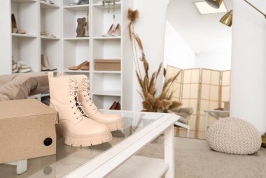 Butikte şık bej çizmeli ve karton kutulu masa, yakın plan.