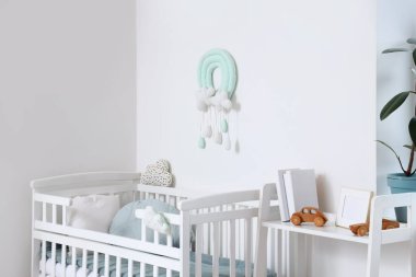 Çocuk odasındaki ışık duvarının yanında rahat bir bebek yatağı